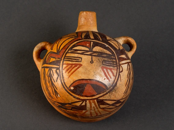 a polychrome canteen with a katsina face