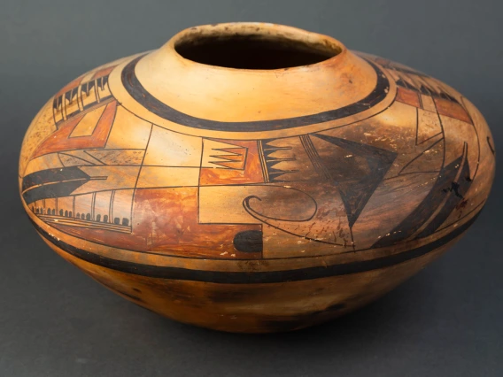 A large Hopi jar with polychrome designs painted on a field of yellow clay.