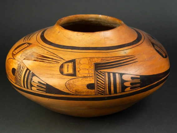 A large Hopi jar with polychrome designs painted on a field of yellow clay.