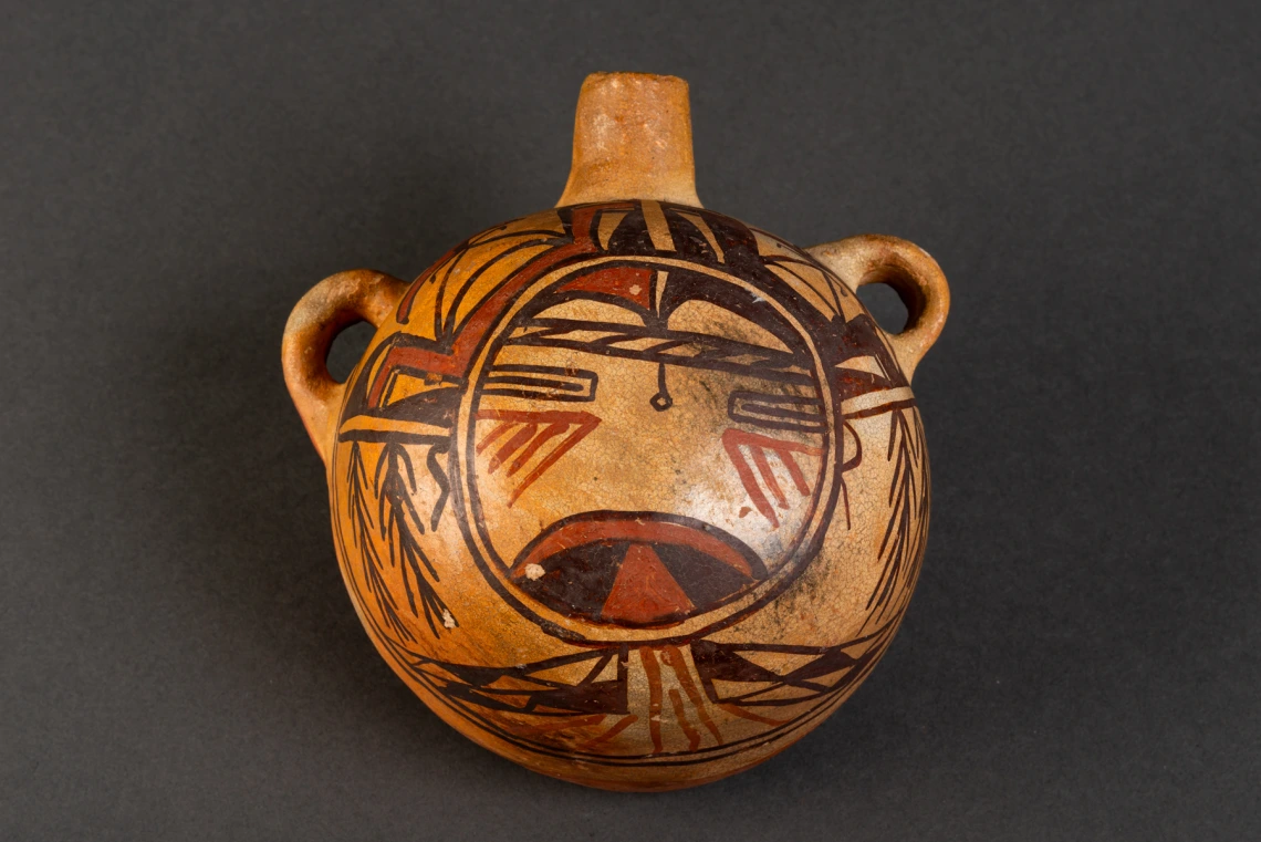 a polychrome canteen with a katsina face