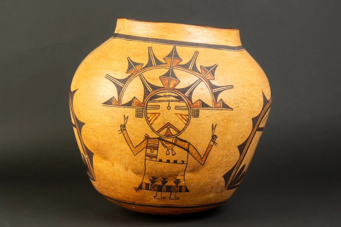 A large Hopi jar with polychrome katsina design painted on a field of yellow clay.