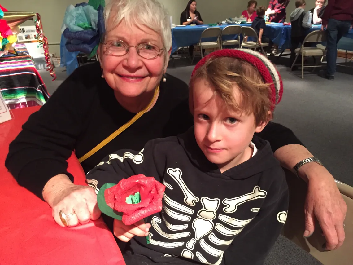 Adult and child sitting at red table